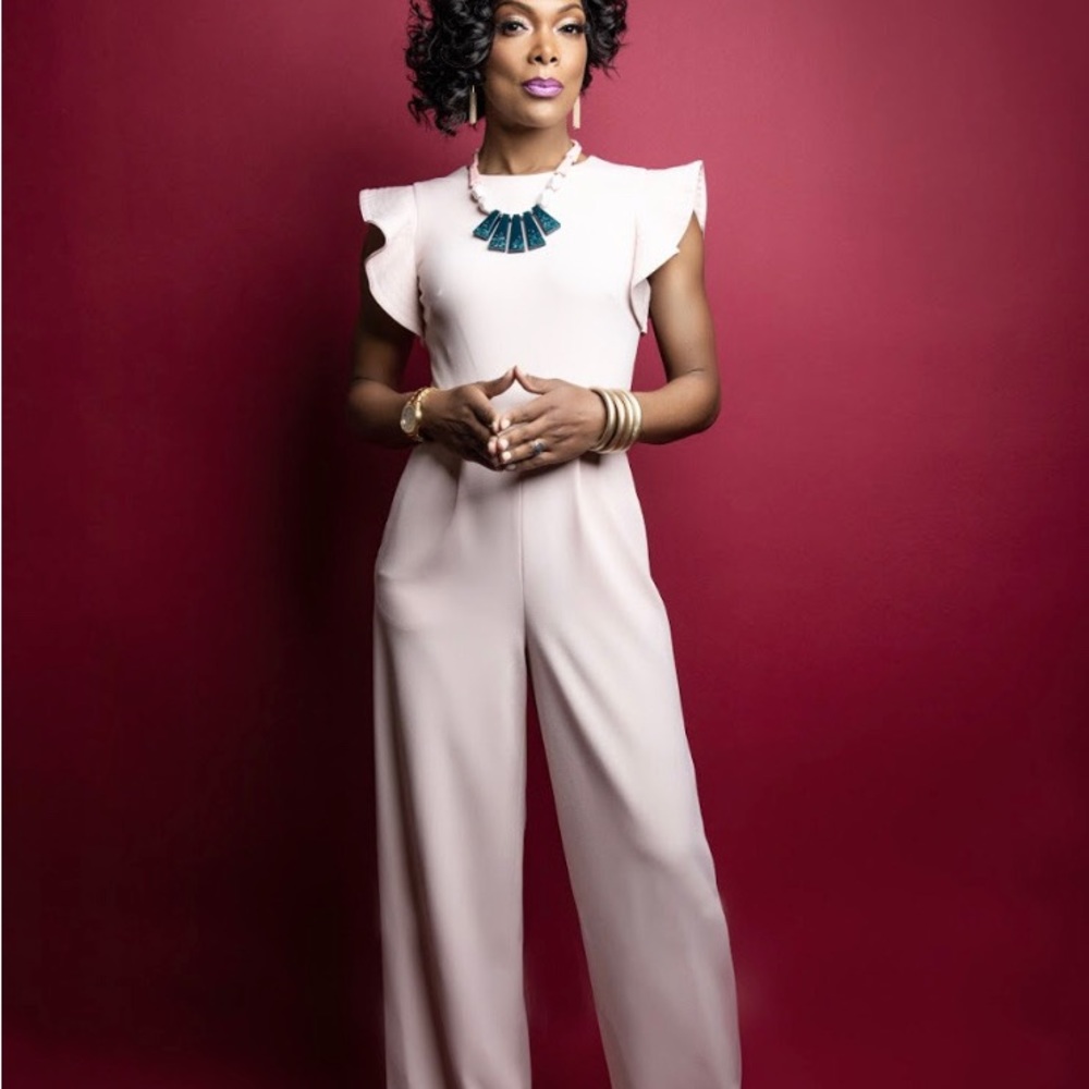 One peice jumper in a soft pink color with ruffled short arms. Wide leg pants.